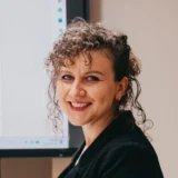 Uśmiechnięta kobieta z kręconymi włosami, Agnieszka Stachnik